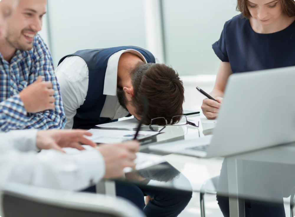 man in office banging head on desk