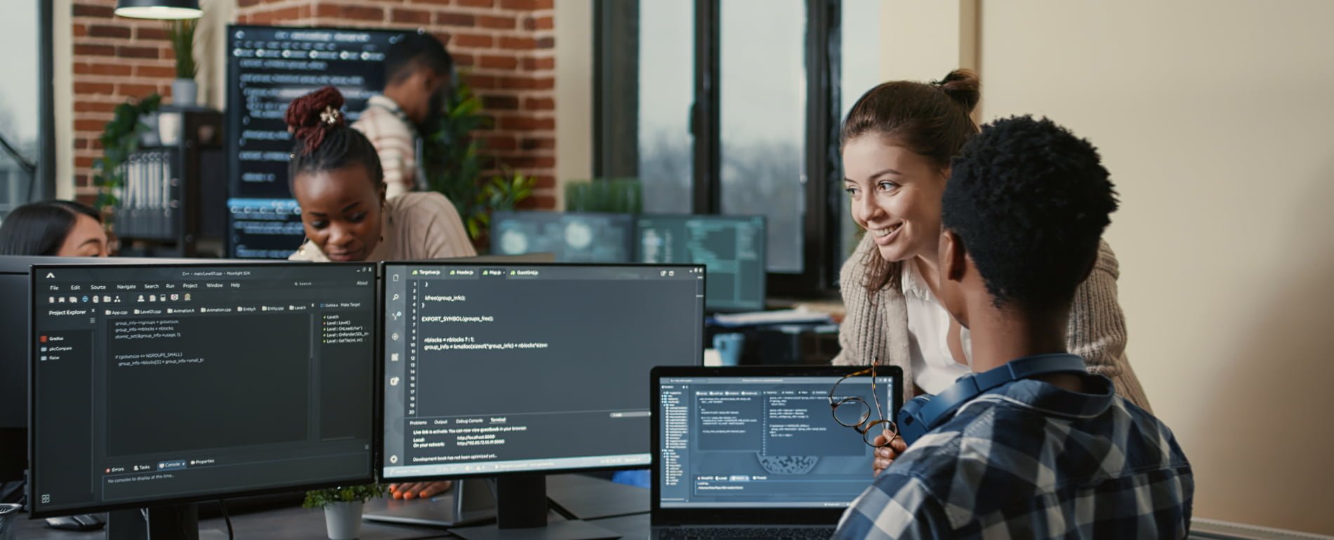 office workers in front of multiple screens