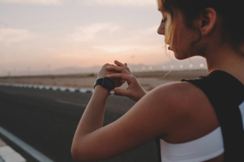 female runner looking at sports watch